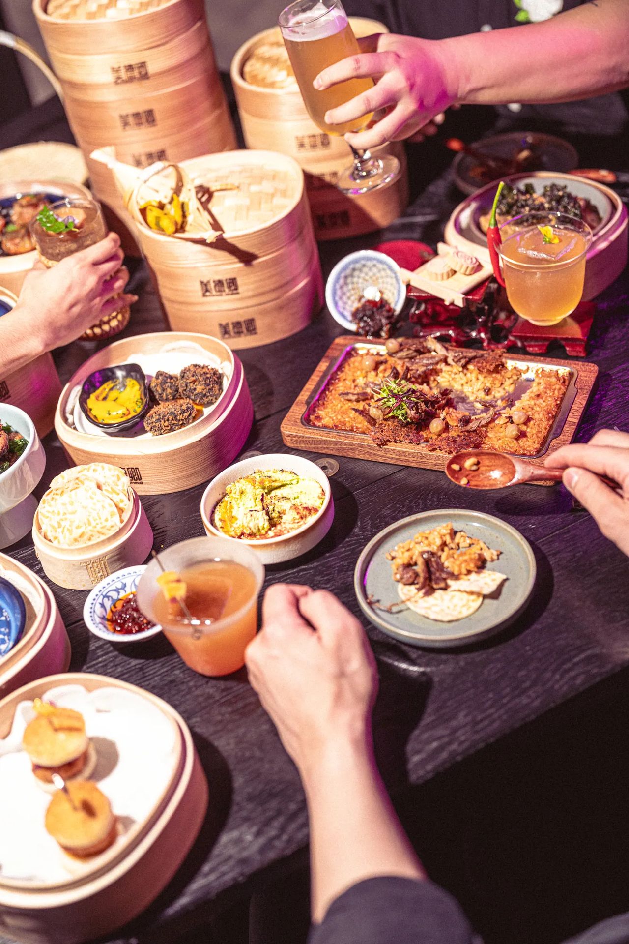 Shared table of Madame Ching dishes and cocktails